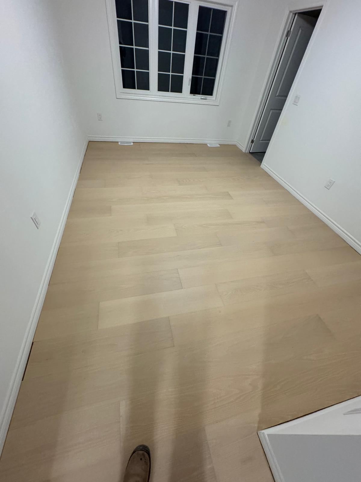 Completed light oak plank flooring installation in a bright room